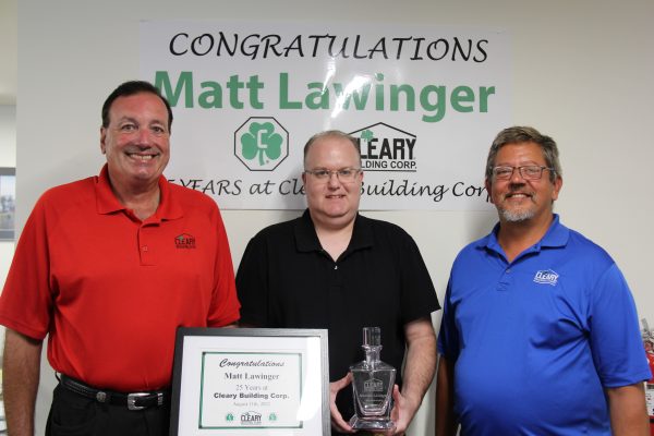 Matt Lawinger stands between Sean Cleary and Karl Lemmenes. He holds the decanter with the certificate in front of him.
