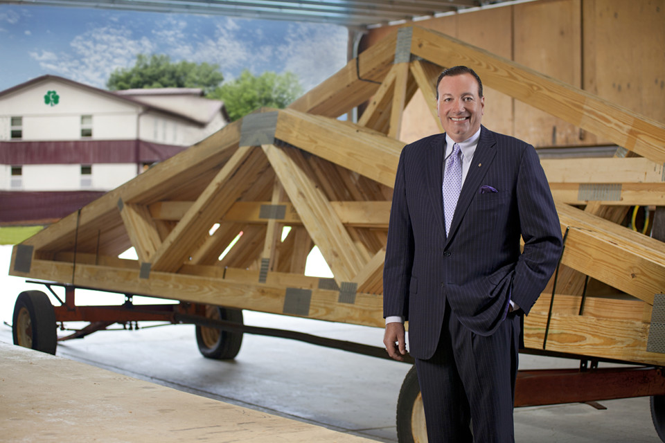 Sean stands in front of trusses which are located in front of the headquarters building.