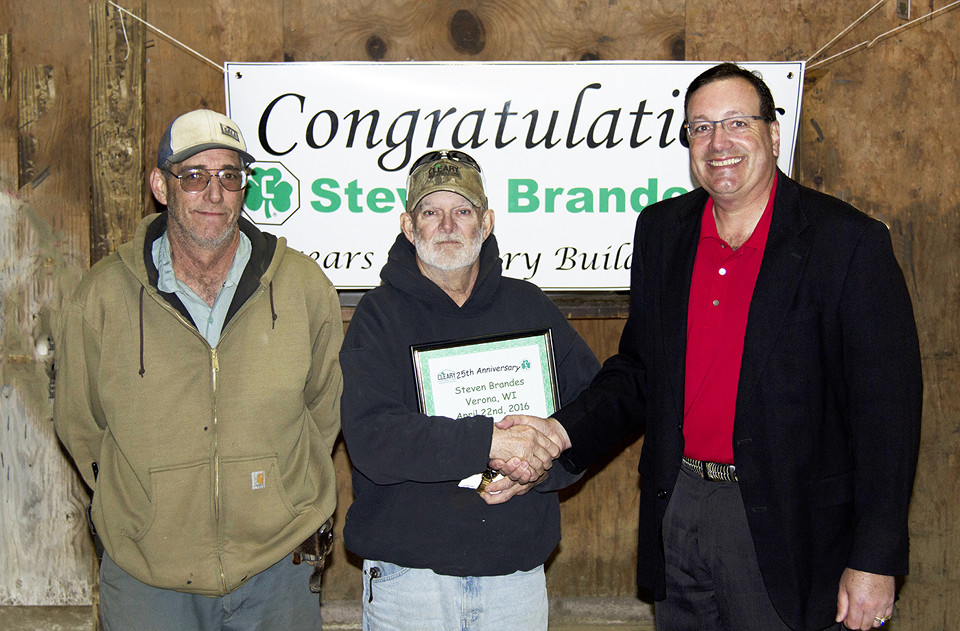 Steve and two others. Steve shakes hands with Sean Cleary as he holds anniversary certificate.