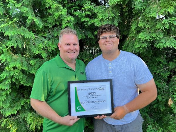 Mike Wuennemann and his son Ashton Wuennemann holding the 2022 Cleary Building Corp. Scholarship.