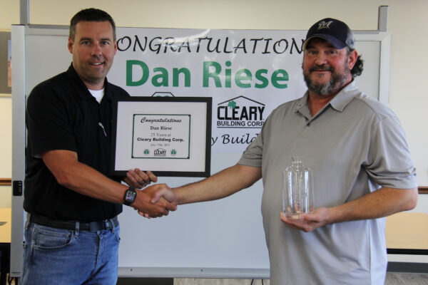 Dan Riese accepting his certificate and decanter while shaking hands with VP of Technology, Jim Schindler.