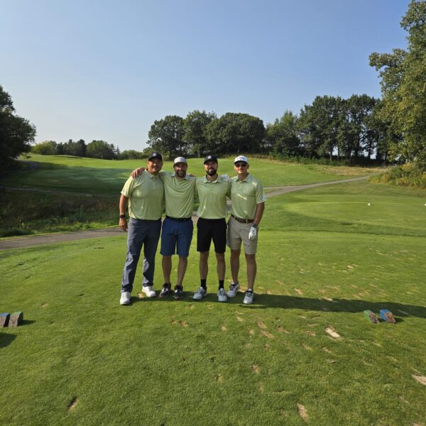 Four golfers posing for picture on the course